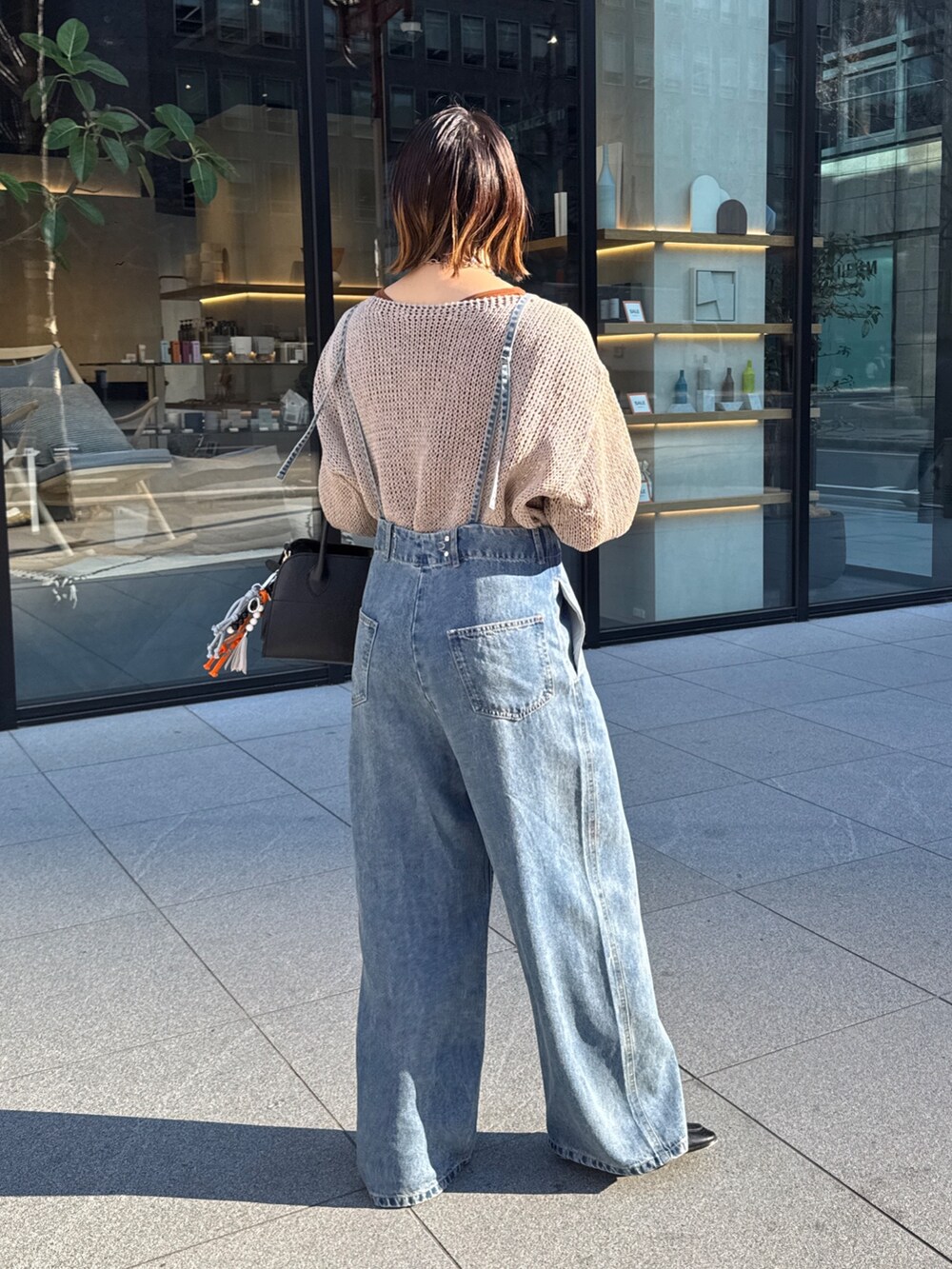 ベージュ系のニット/セーター、ブルー系のデニムパンツ、ブラウン系のTシャツ/カットソーを着用したレディースの冬コーディネートの4枚目の写真