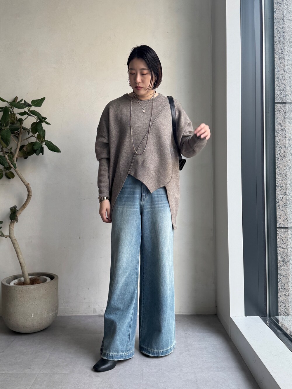 ブルー系のその他アウター、ブルー系のデニムパンツ、グリーン系のニット/セーターを着用したレディースの秋コーディネートの8枚目の写真