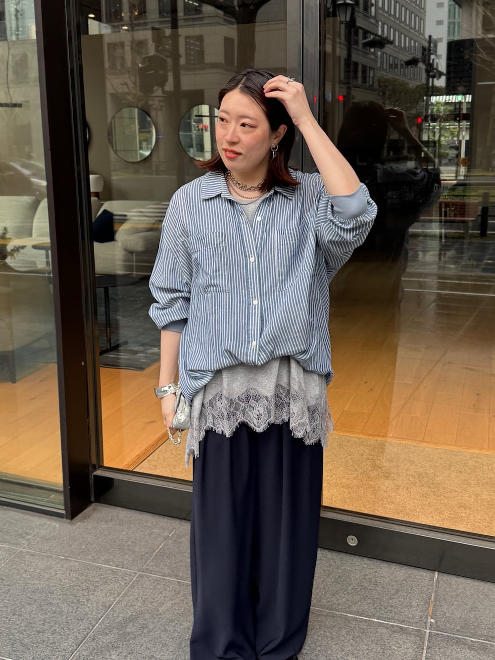 グレー系のTシャツ/カットソー、ブルー系のシャツ/ブラウス、ブルー系のスラックスを着用したレディースの春コーディネートの3枚目の写真