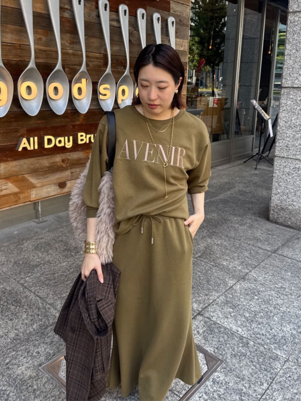 グリーン系のTシャツ/カットソー、グリーン系のスカート、ブラウン系のテーラードジャケットを着用したレディースの夏コーディネートの3枚目の写真