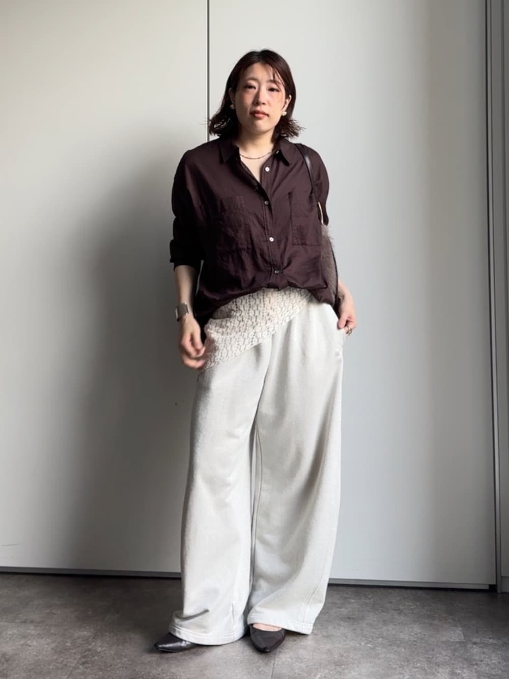 ブラウン系のシャツ/ブラウス、ホワイト系のスウェットパンツ、ブラウン系のトートバッグを着用したレディースの秋コーディネートの5枚目の写真