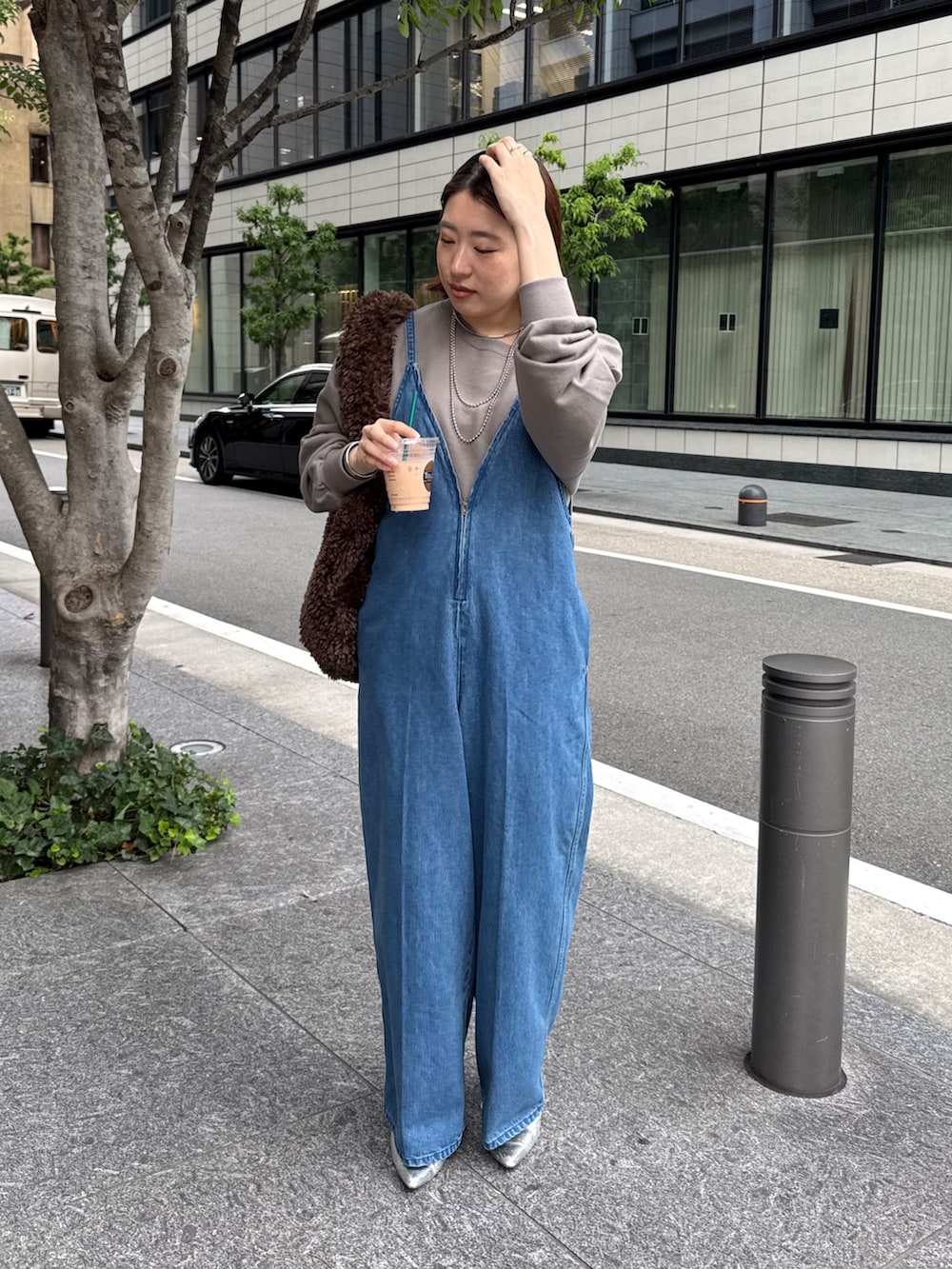 ブルー系のつなぎ/オールインワン、ベージュ系のスウェット、ブラウン系のショルダーバッグを着用したレディースの秋コーディネートの2枚目の写真