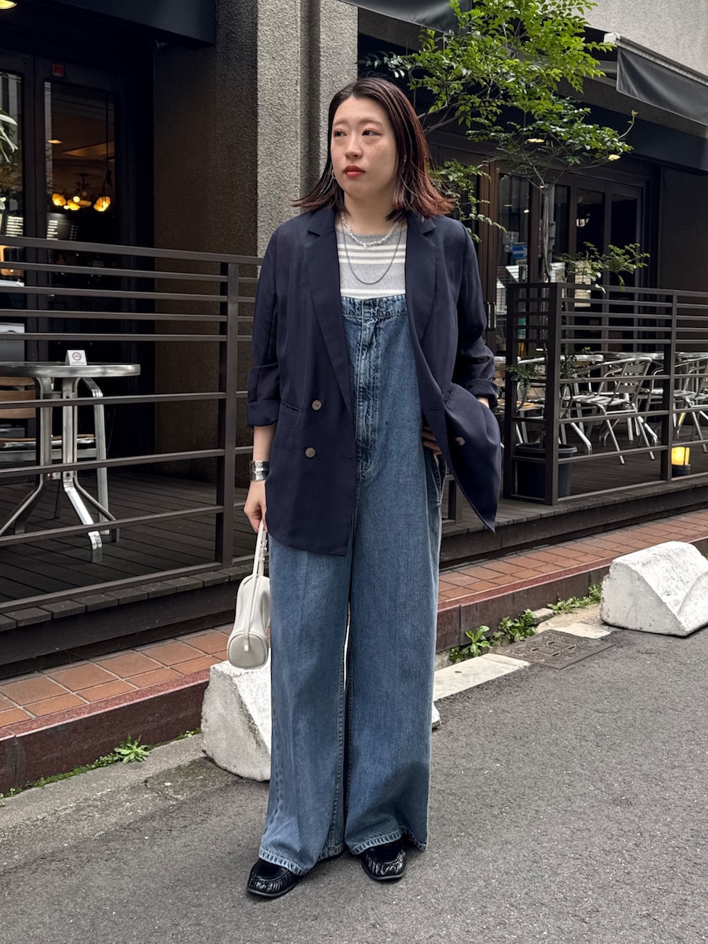 ブルー系のつなぎ/オールインワン、ブルー系のテーラードジャケット、グレー系のニット/セーターを着用したレディースの春コーディネートの2枚目の写真