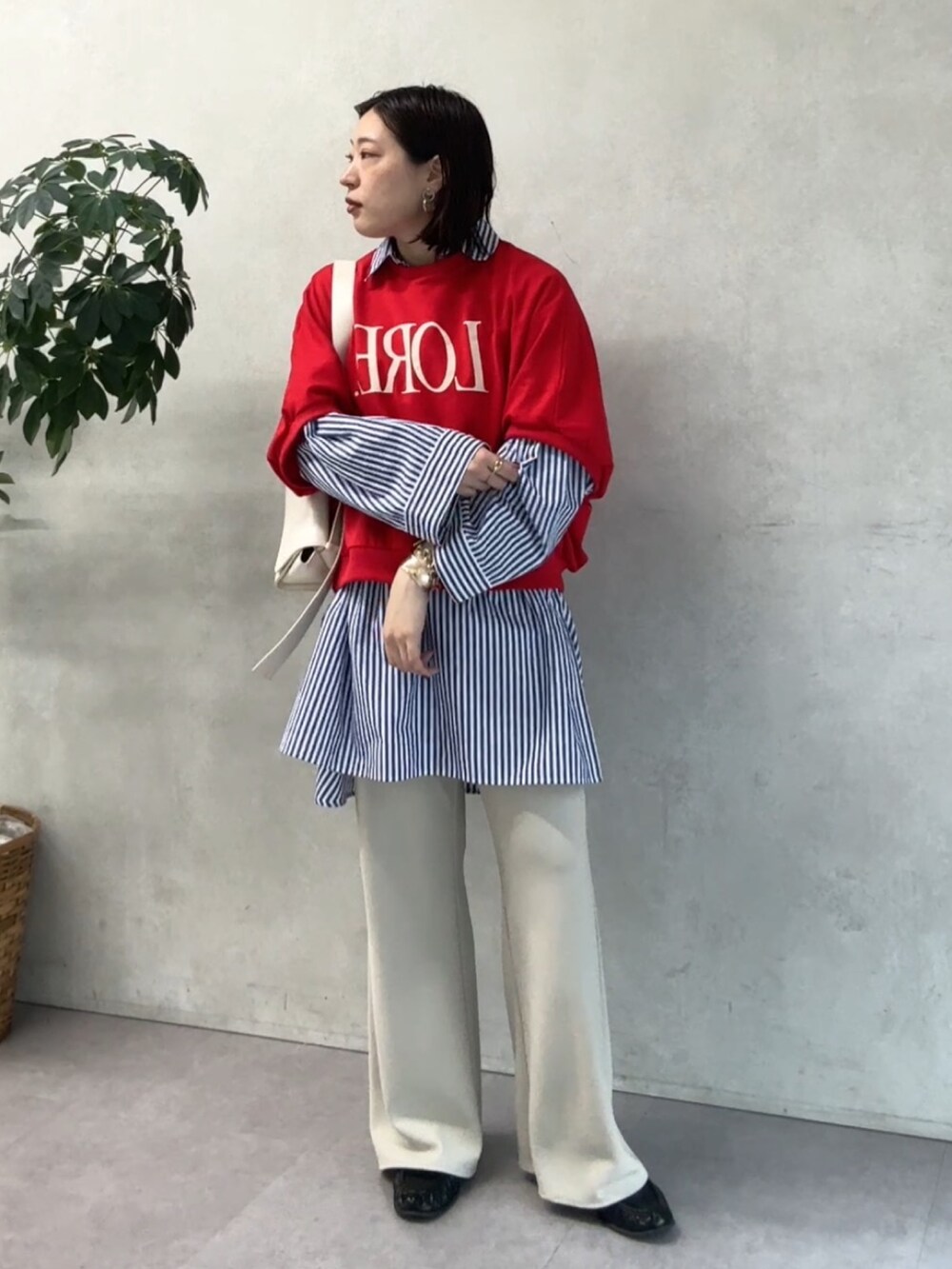 ブルー系のシャツ/ブラウス、レッド系のTシャツ/カットソー、ベージュ系のその他パンツを着用したレディースの春コーディネートの2枚目の写真