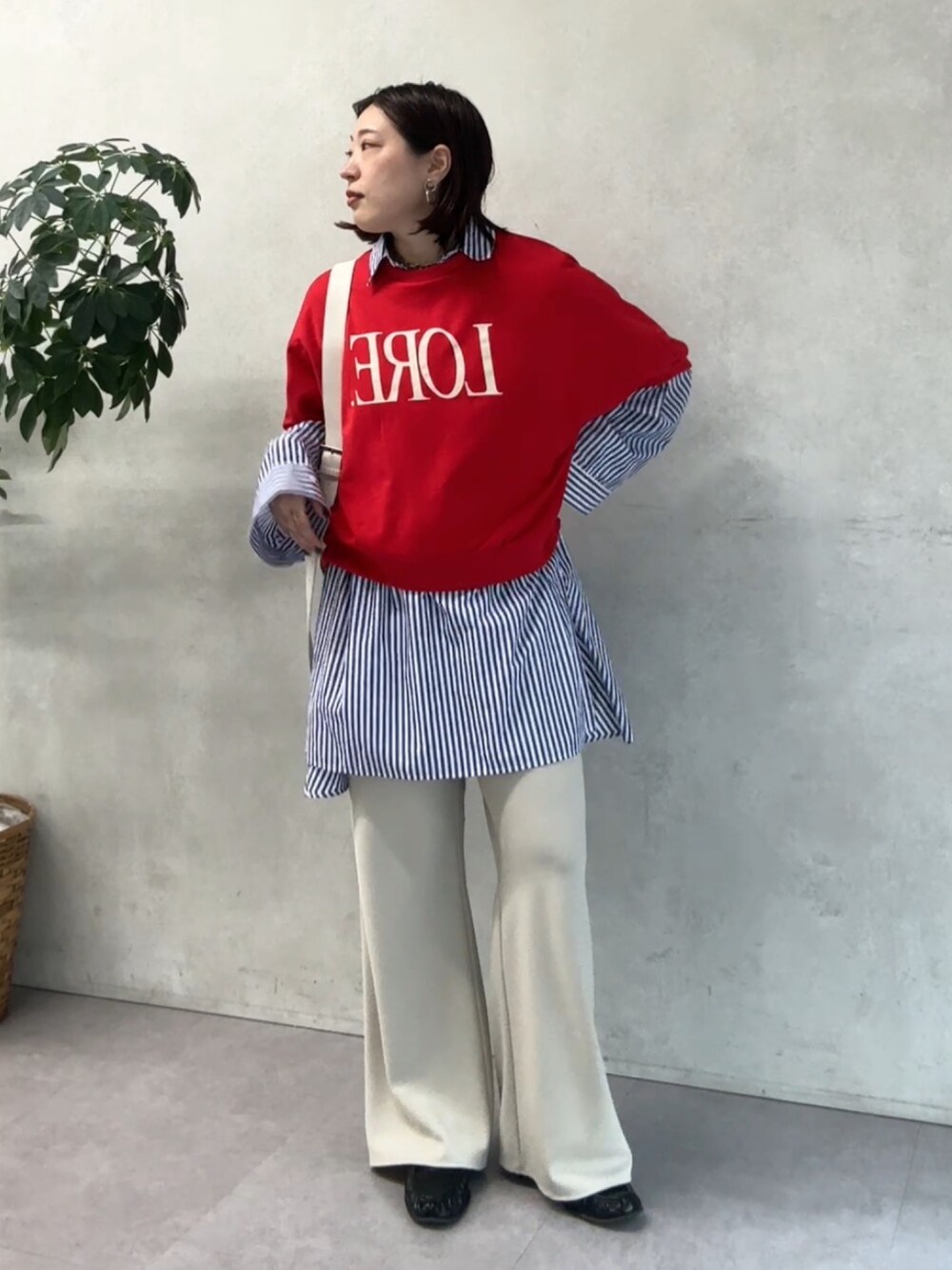 ブルー系のシャツ/ブラウス、レッド系のTシャツ/カットソー、ベージュ系のその他パンツを着用したレディースの春コーディネートの3枚目の写真