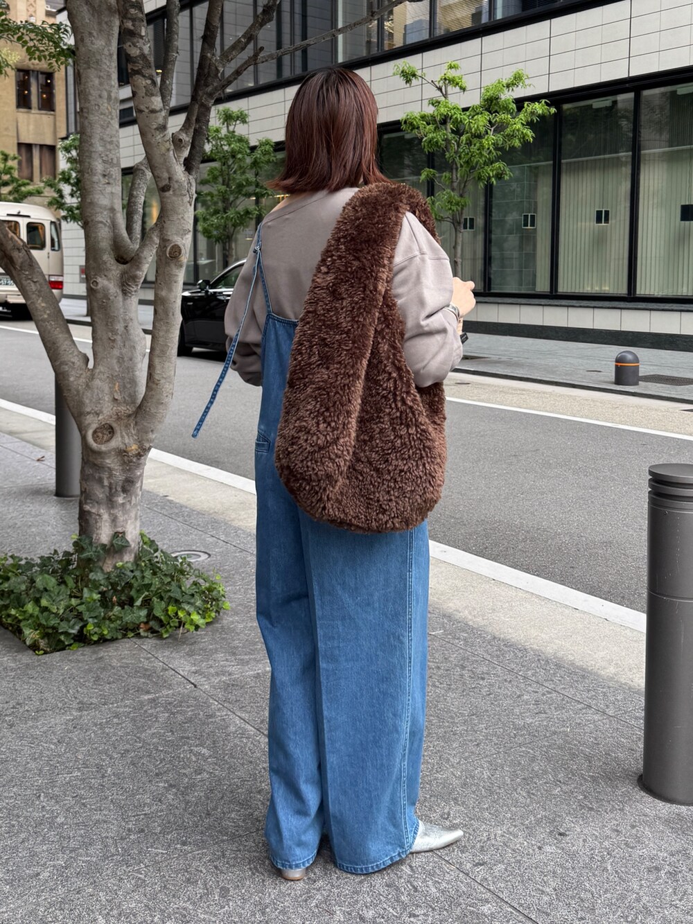 ブルー系のつなぎ/オールインワン、ベージュ系のスウェット、ブラウン系のショルダーバッグを着用したレディースの秋コーディネートの4枚目の写真
