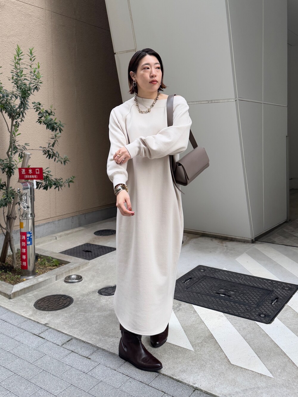 ベージュ系のワンピース、ブラウン系のその他アウター、ブラウン系のブーツを着用したレディースの冬コーディネートの7枚目の写真