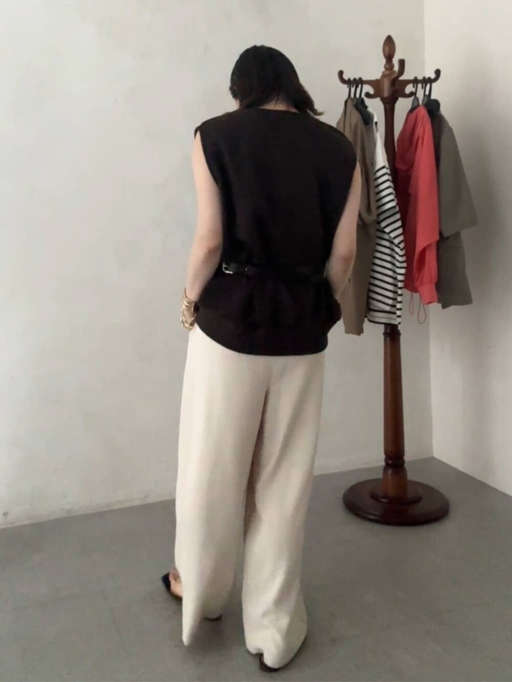 ブラウン系のショルダーバッグ、ブラウン系のTシャツ/カットソー、ベージュ系のスラックスを着用したレディースの夏コーディネートの5枚目の写真