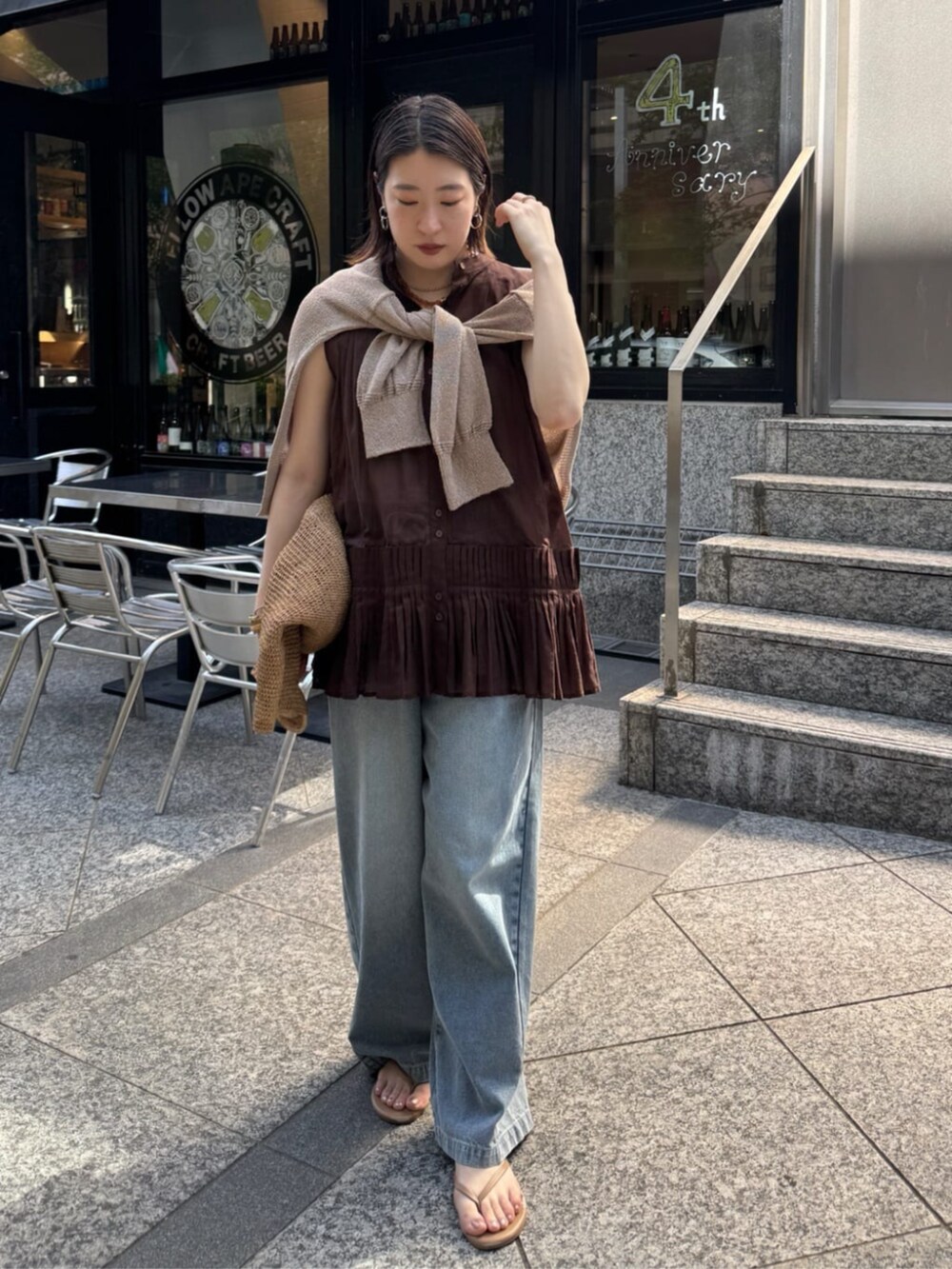 ブルー系のデニムパンツ、ベージュ系のカーディガン/ボレロ、ブラウン系のシャツ/ブラウスを着用したレディースの春コーディネートの8枚目の写真