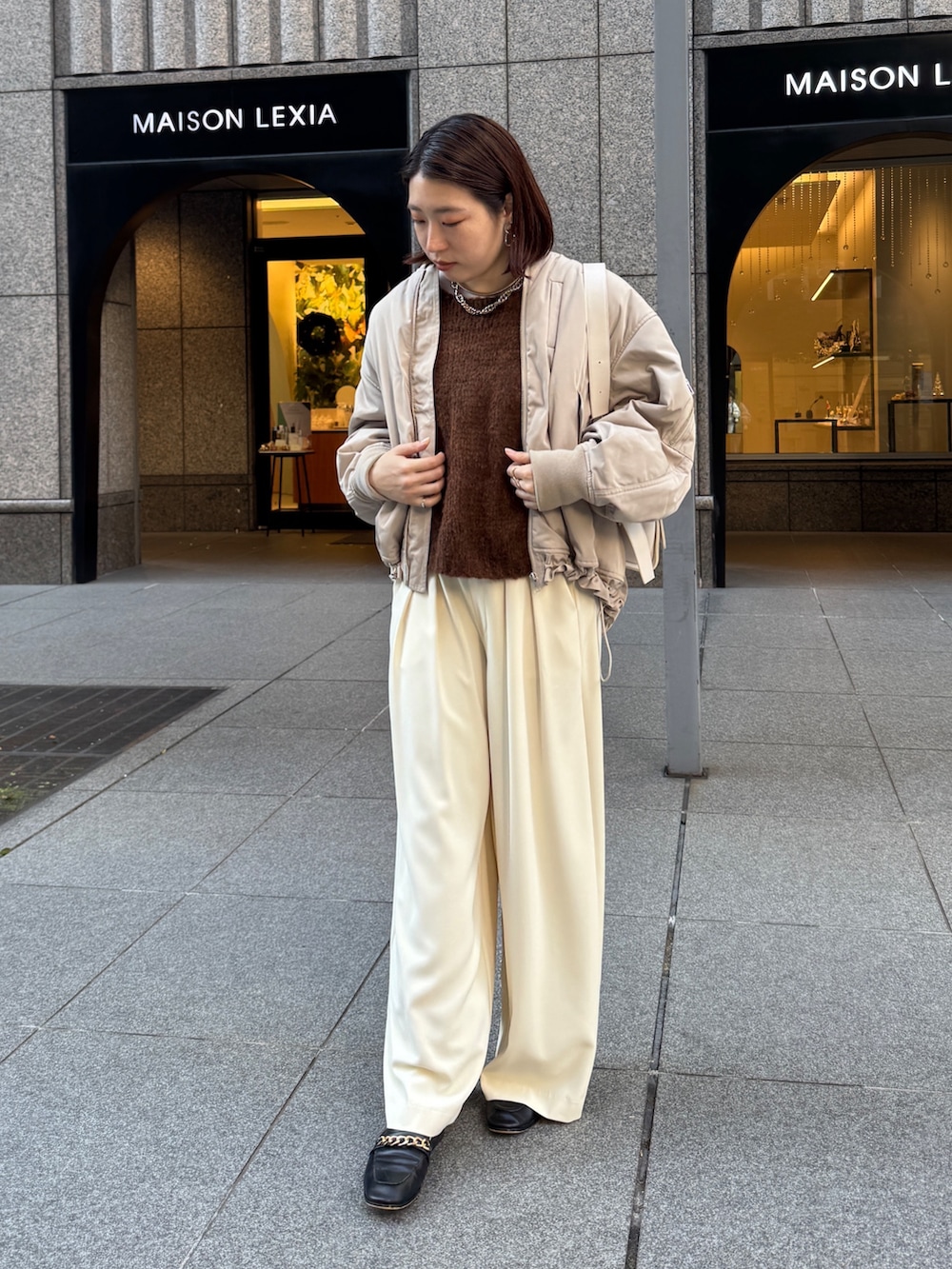 イエロー系のスラックス、ベージュ系のMA-1、ブラウン系のニット/セーターを着用したレディースの秋コーディネートの2枚目の写真
