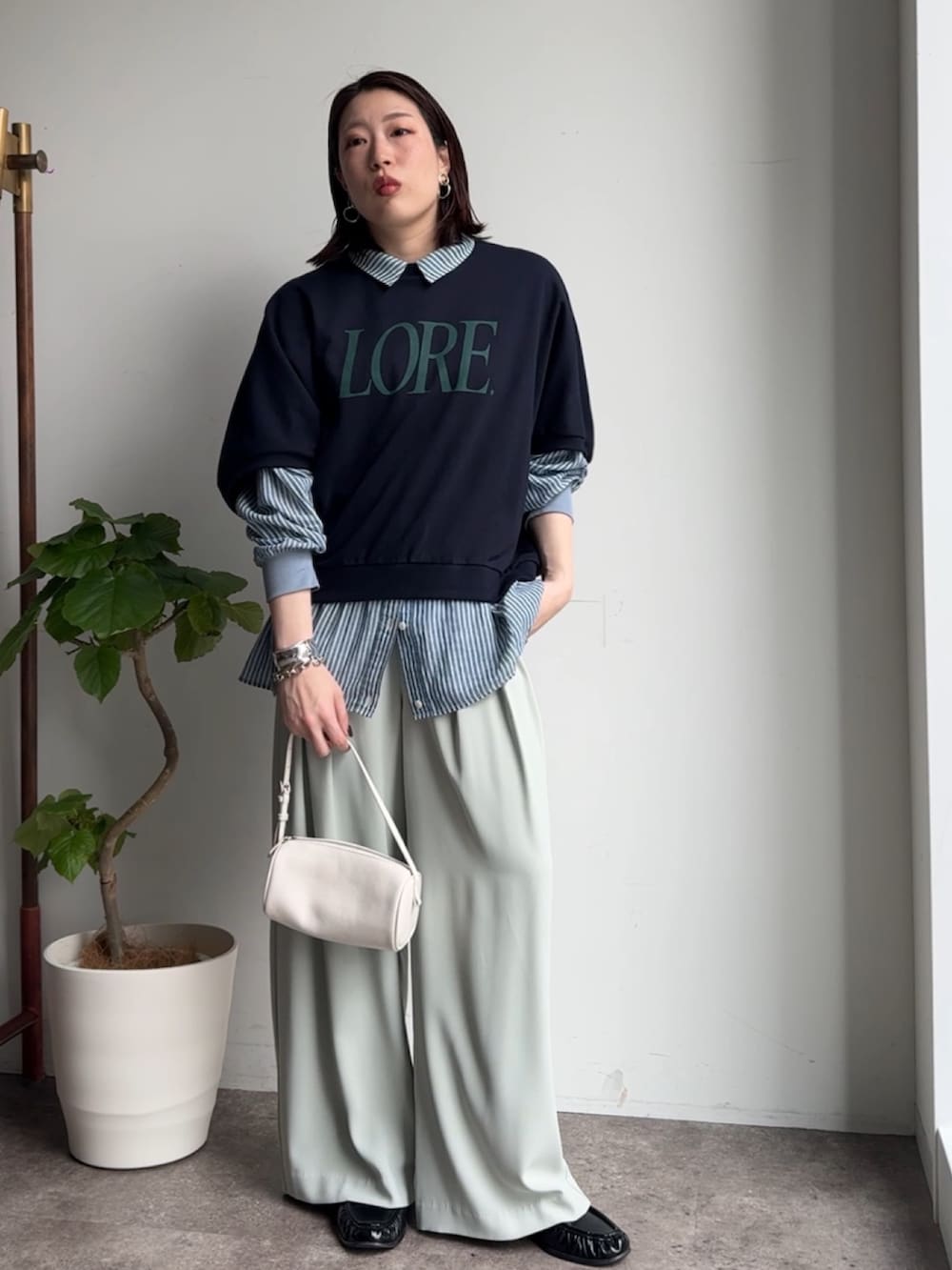 グリーン系のスラックス、ブルー系のシャツ/ブラウス、ブルー系のTシャツ/カットソーを着用したレディースの春コーディネートの6枚目の写真