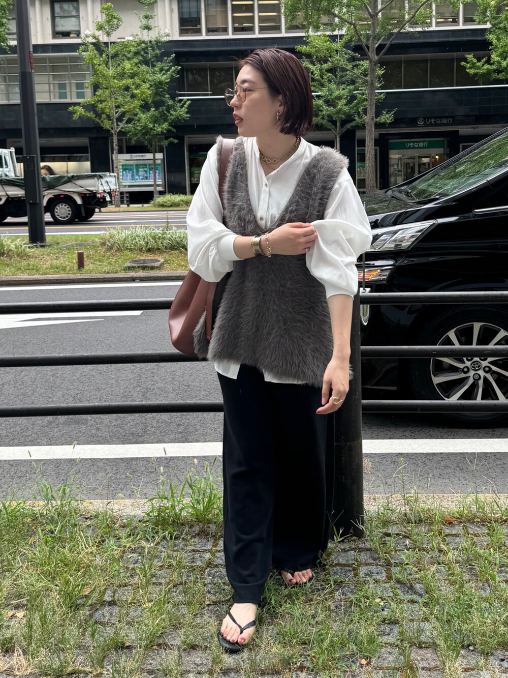 グレー系のニット/セーター、ブラック系のその他パンツ、ブラウン系のショルダーバッグを着用したレディースの夏コーディネートの2枚目の写真