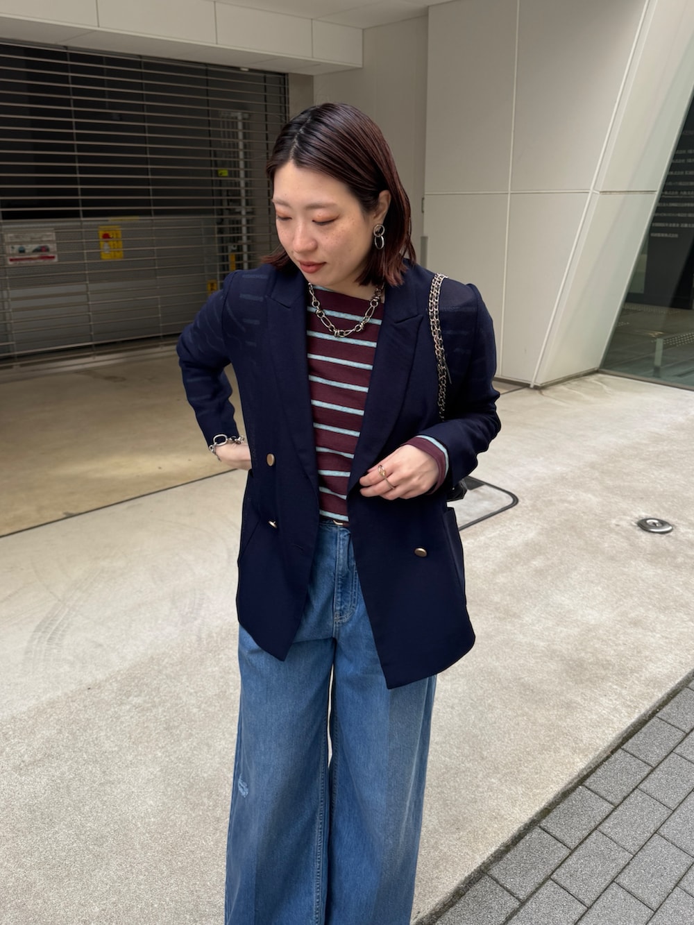 ブルー系のデニムパンツ、ブルー系のテーラードジャケット、ブラウン系のTシャツ/カットソーを着用したレディースの春コーディネートの5枚目の写真