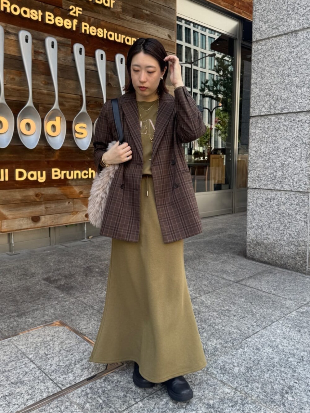 グリーン系のTシャツ/カットソー、グリーン系のスカート、ブラウン系のテーラードジャケットを着用したレディースの夏コーディネートの6枚目の写真