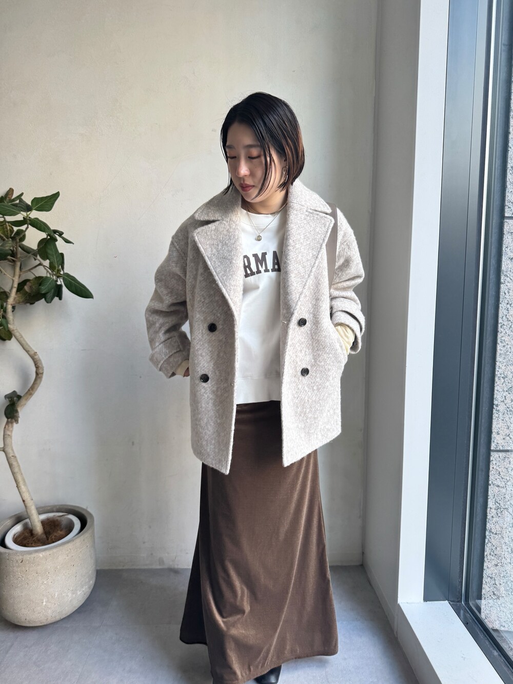 ベージュ系のその他アウター、ブラウン系のスカート、ホワイト系のTシャツ/カットソーを着用したレディースの冬コーディネートの4枚目の写真