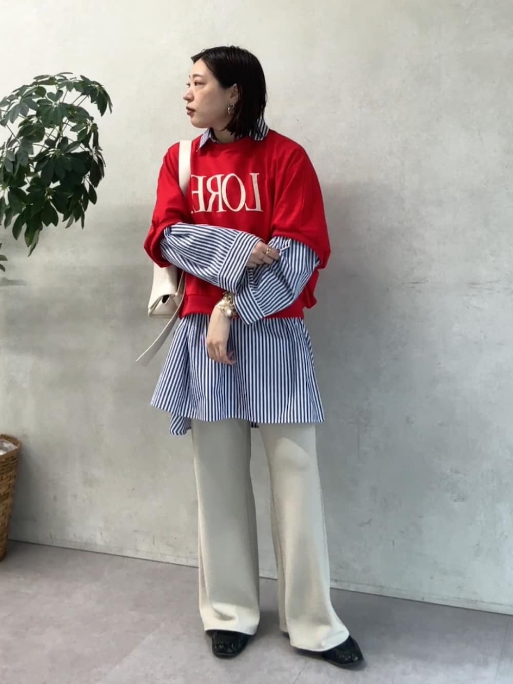 ブルー系のシャツ/ブラウス、レッド系のTシャツ/カットソー、ベージュ系のその他パンツを着用したレディースの春コーディネートの5枚目の写真