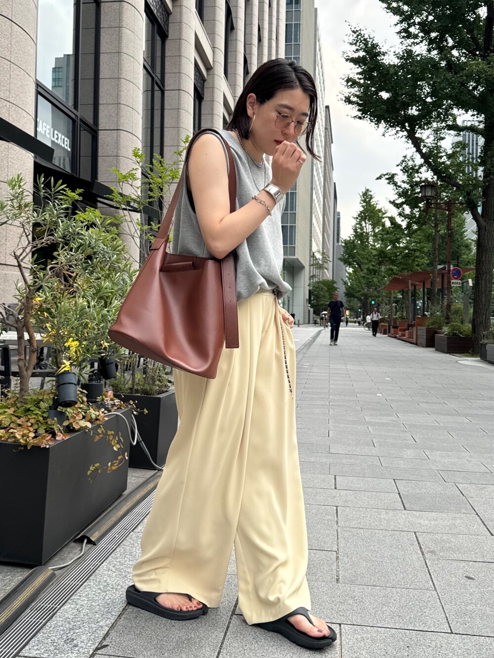 イエロー系のスラックス、グレー系のスウェット、シルバー系のベルトを着用したレディースの夏コーディネートの6枚目の写真