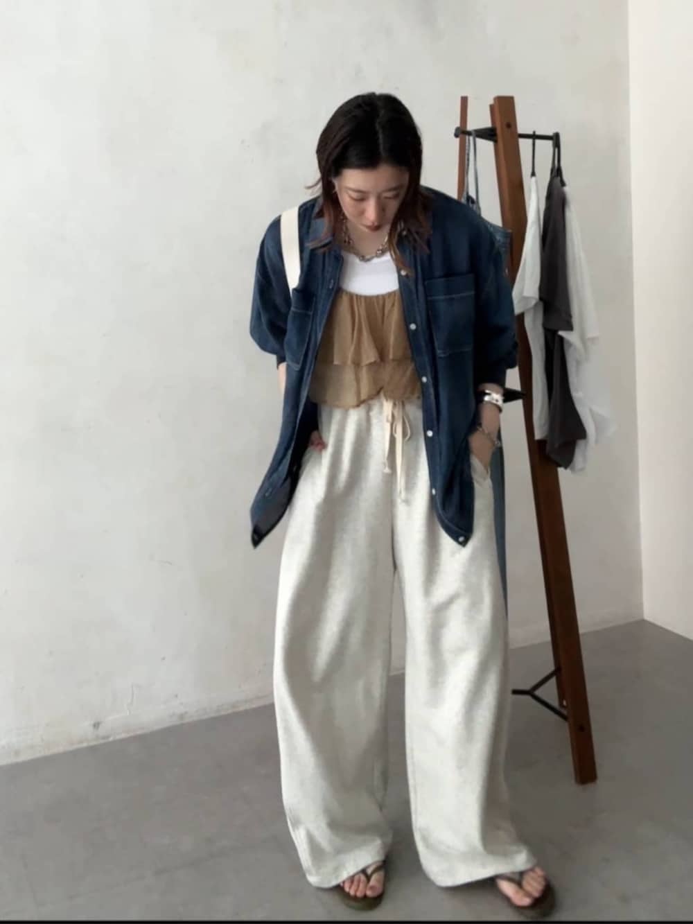 ホワイト系のショルダーバッグ、ベージュ系のその他パンツ、ブルー系のシャツ/ブラウスを着用したレディースの春コーディネートの3枚目の写真