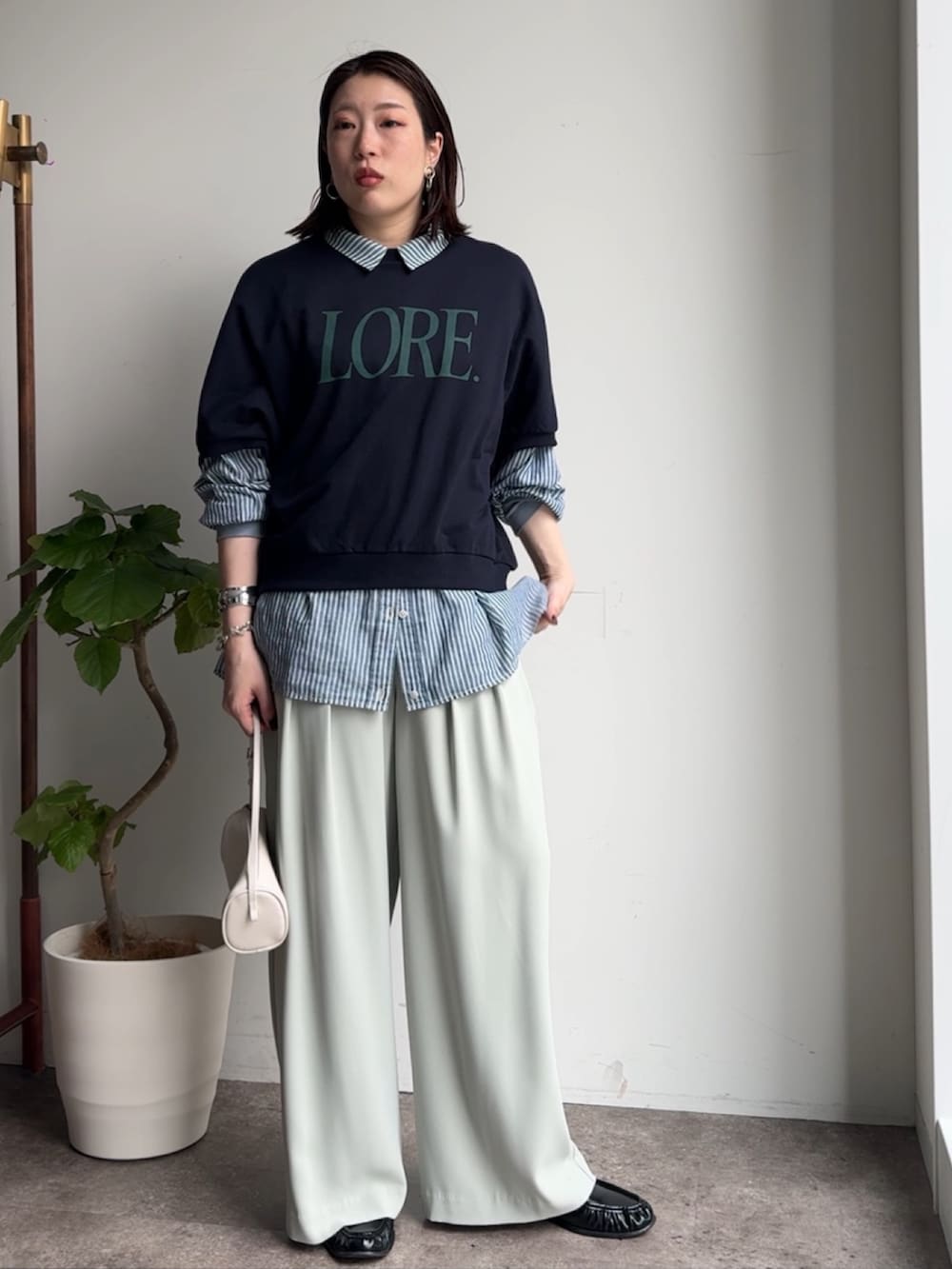 グリーン系のスラックス、ブルー系のシャツ/ブラウス、ブルー系のTシャツ/カットソーを着用したレディースの春コーディネートの5枚目の写真