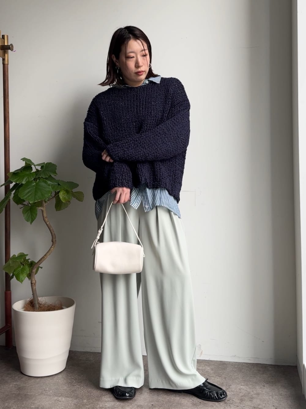 ブルー系のニット/セーター、ブルー系のシャツ/ブラウス、グリーン系のスラックスを着用したレディースの冬コーディネートの3枚目の写真