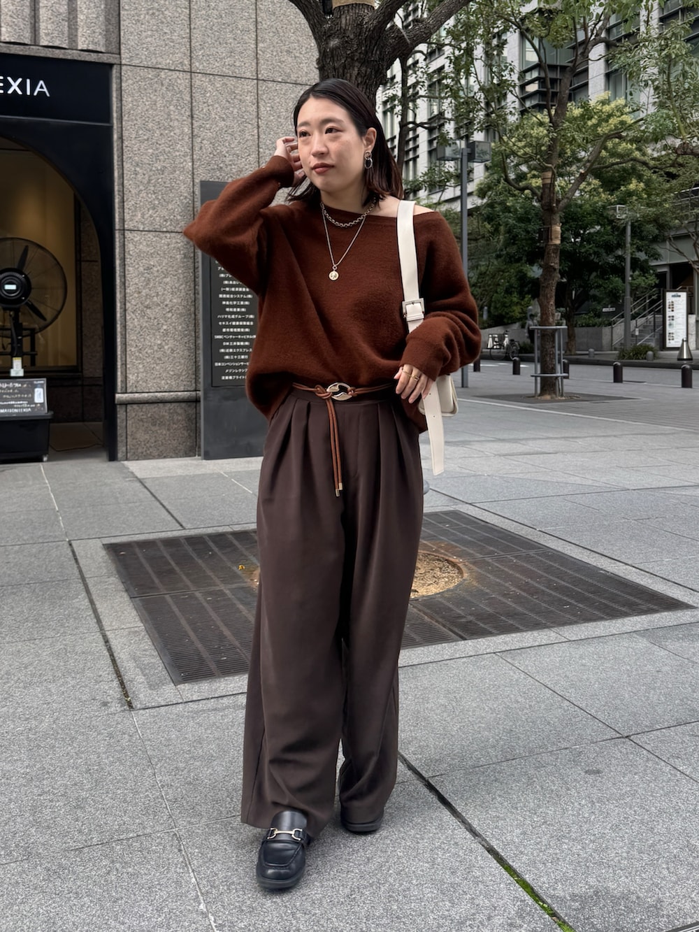 ブラウン系のニット/セーター、ブラウン系のスラックス、ブラウン系のベルトを着用したレディースの秋コーディネートの2枚目の写真
