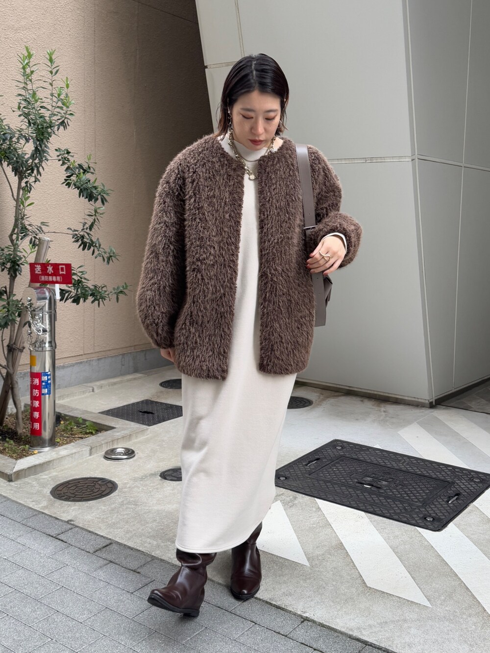 ベージュ系のワンピース、ブラウン系のその他アウター、ブラウン系のブーツを着用したレディースの冬コーディネートの3枚目の写真