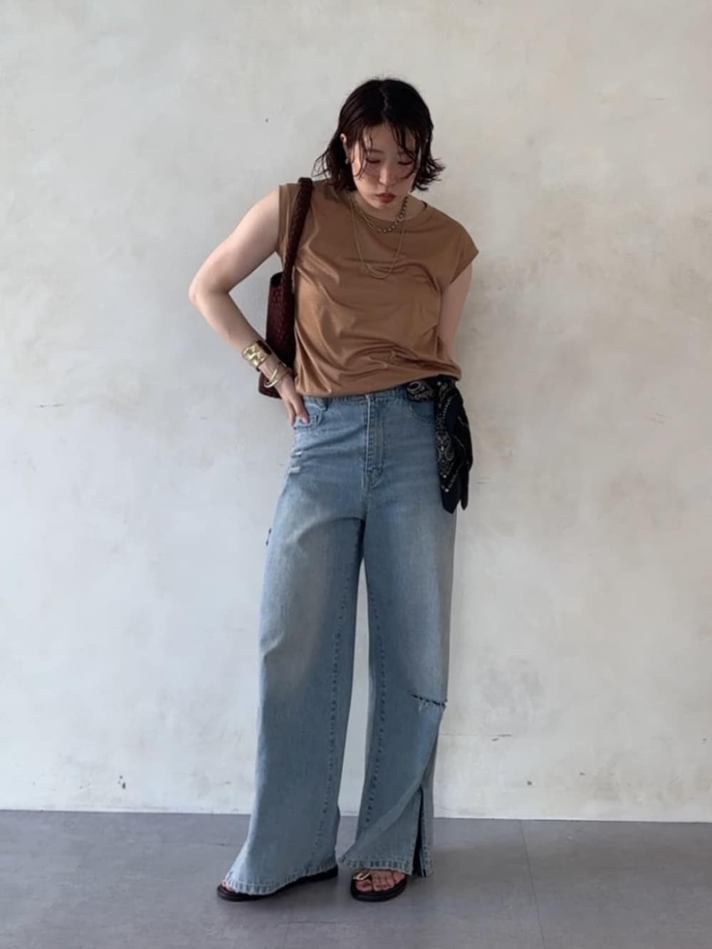 ブルー系のデニムパンツ、ブラウン系のサンダル、イエロー系のTシャツ/カットソーを着用したレディースの夏コーディネートの5枚目の写真