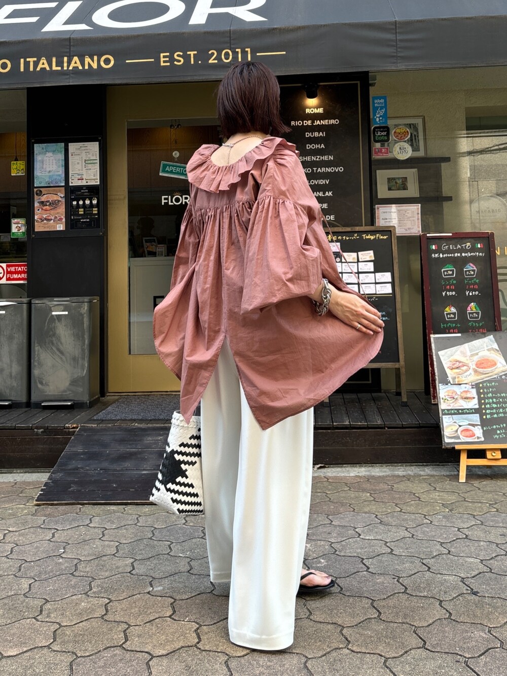 ホワイト系のスラックス、ブラウン系のシャツ/ブラウス、ホワイト系のかごバッグを着用したレディースの夏コーディネートの4枚目の写真