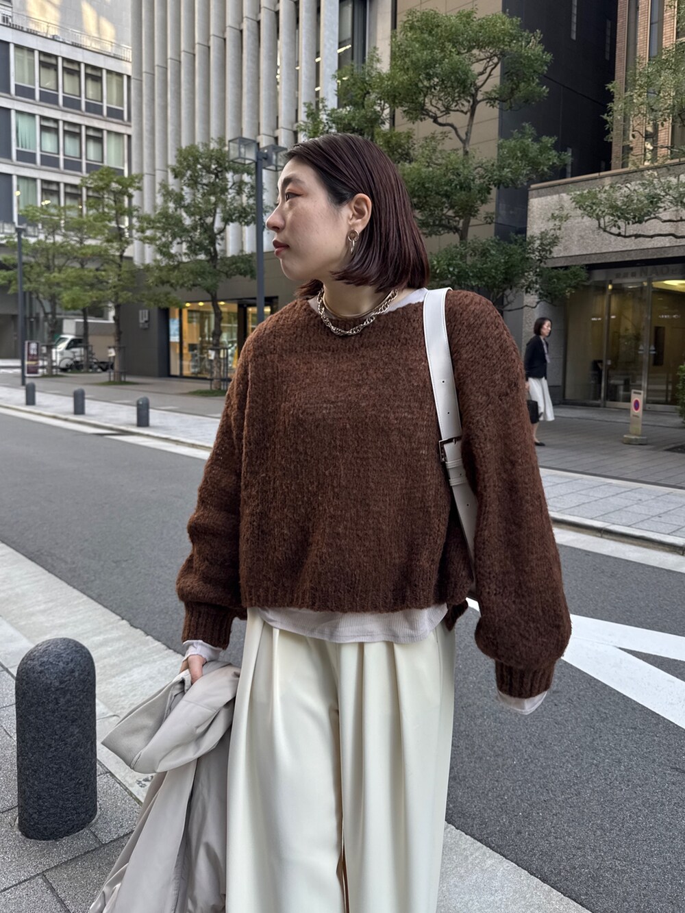 イエロー系のスラックス、ベージュ系のMA-1、ブラウン系のニット/セーターを着用したレディースの秋コーディネートの9枚目の写真