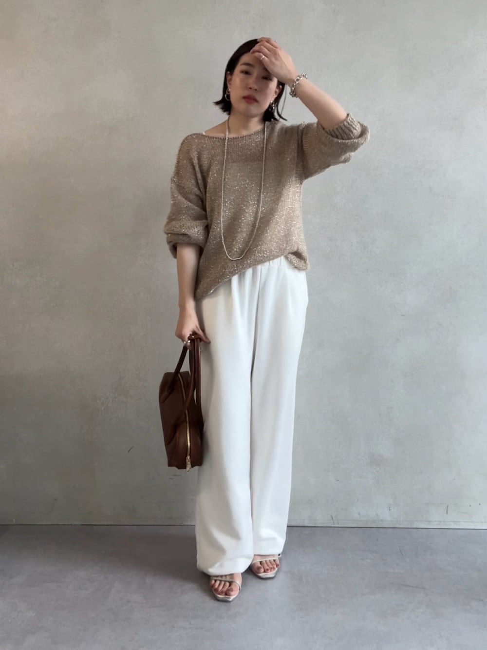 ホワイト系のスウェットパンツ、ベージュ系のニット/セーター、ブラウン系のショルダーバッグを着用したレディースの秋コーディネートの4枚目の写真