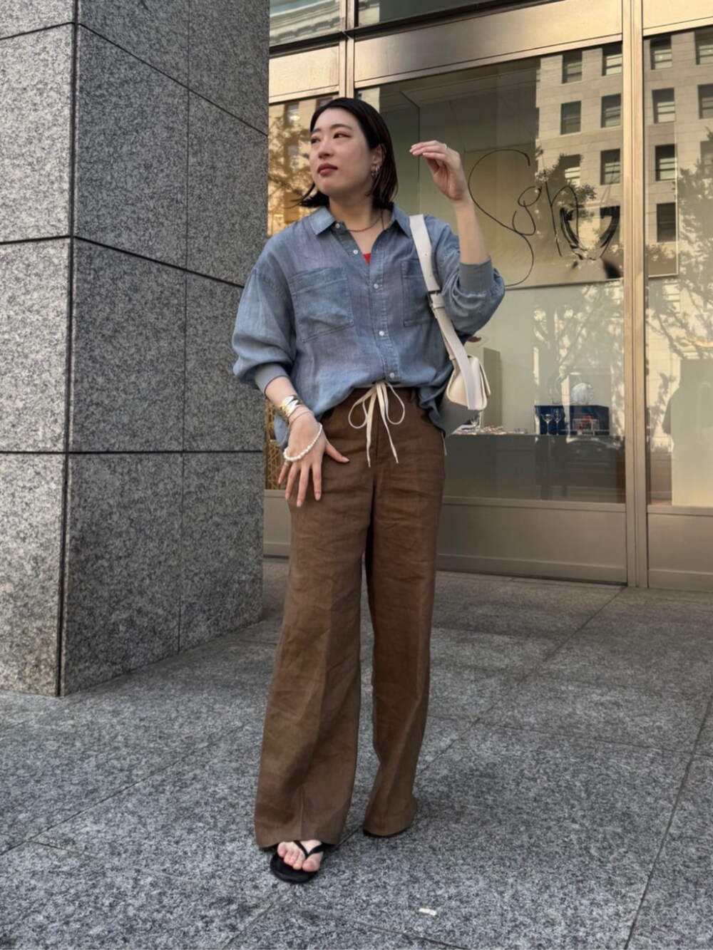 ホワイト系のショルダーバッグ、ブルー系のシャツ/ブラウス、オレンジ系のタンクトップを着用したレディースの春コーディネートの8枚目の写真