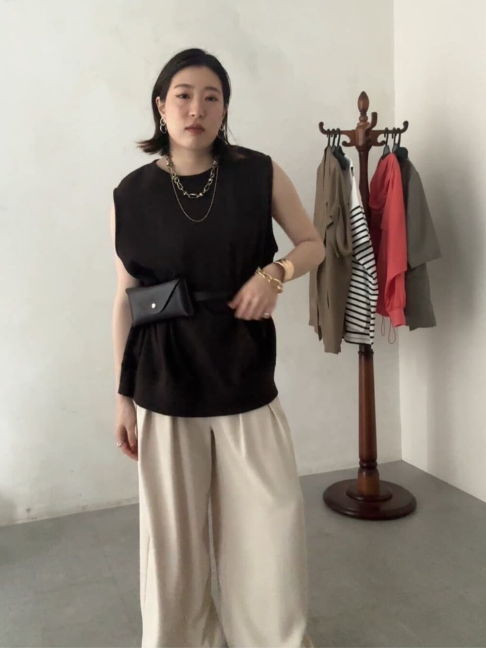 ブラウン系のショルダーバッグ、ブラウン系のTシャツ/カットソー、ベージュ系のスラックスを着用したレディースの夏コーディネートの6枚目の写真