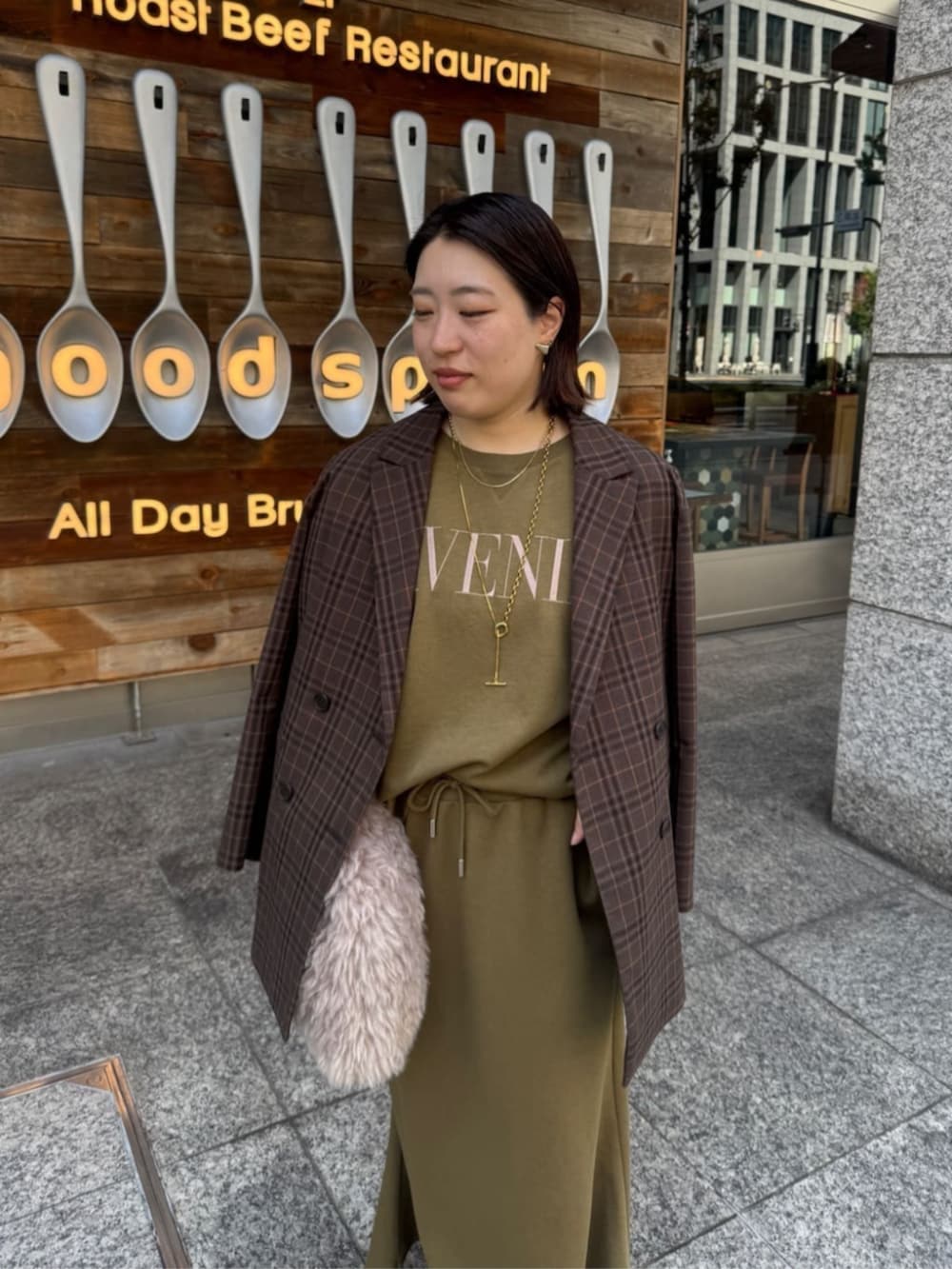 グリーン系のTシャツ/カットソー、グリーン系のスカート、ブラウン系のテーラードジャケットを着用したレディースの夏コーディネートの4枚目の写真