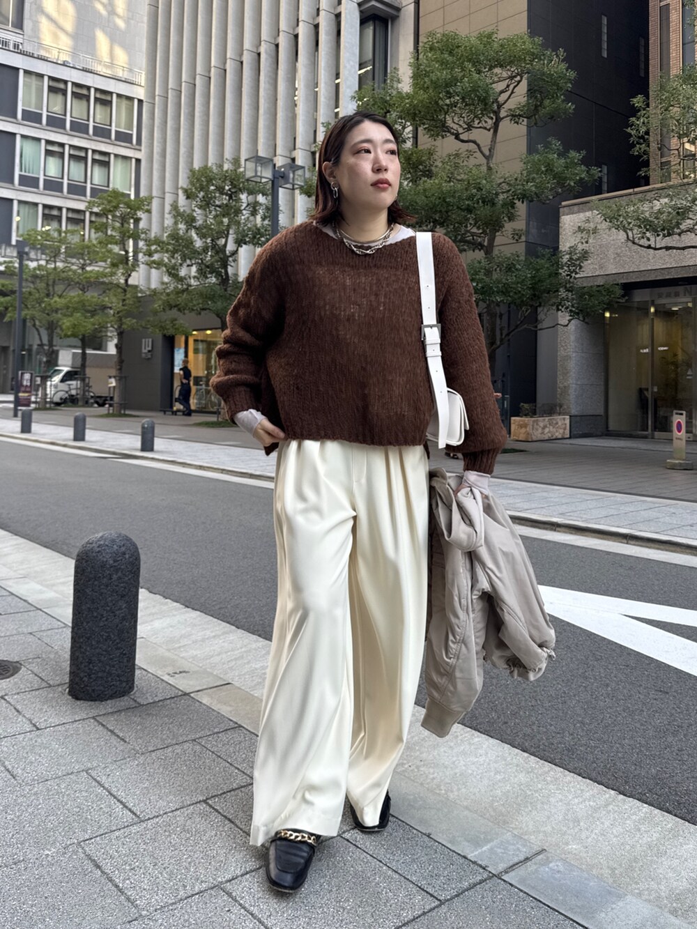 イエロー系のスラックス、ベージュ系のMA-1、ブラウン系のニット/セーターを着用したレディースの秋コーディネートの8枚目の写真