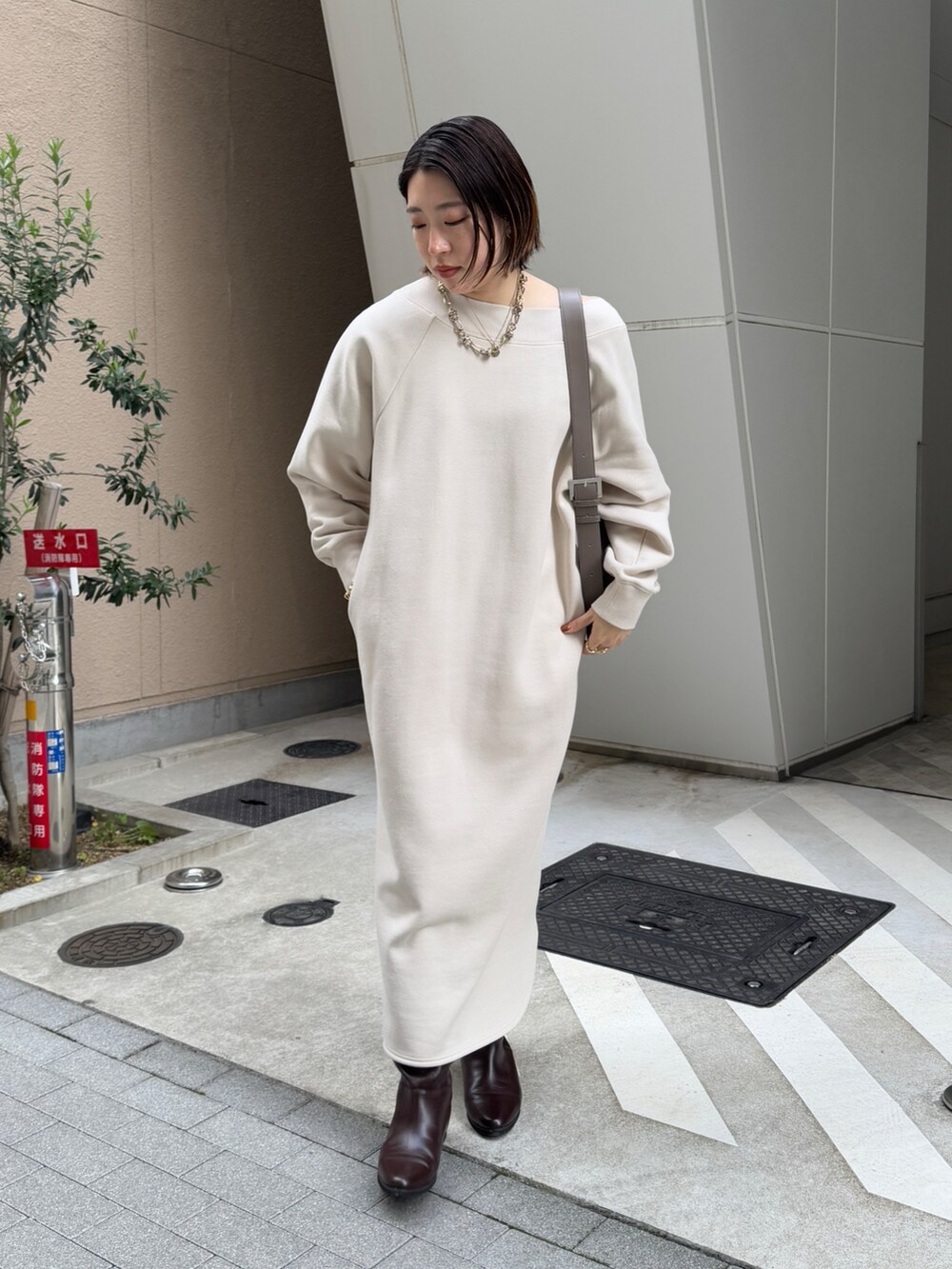 ベージュ系のワンピース、ブラウン系のその他アウター、ブラウン系のブーツを着用したレディースの冬コーディネートの6枚目の写真