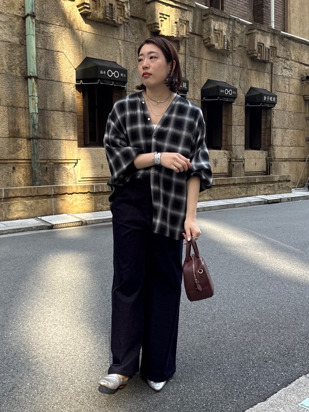 ブラック系のその他パンツ、ブラック系のシャツ/ブラウス、ブラウン系のニット/セーターを着用したレディースの秋コーディネートの7枚目の写真