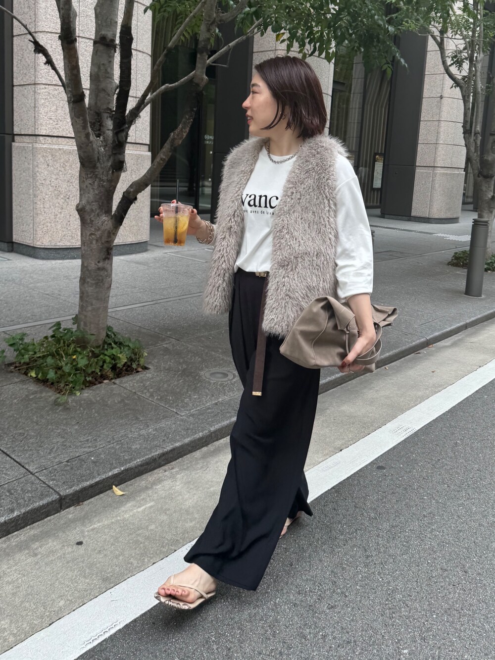 ブラック系のスラックス、グレー系のベスト、ホワイト系のTシャツ/カットソーを着用したレディースの夏コーディネートの2枚目の写真