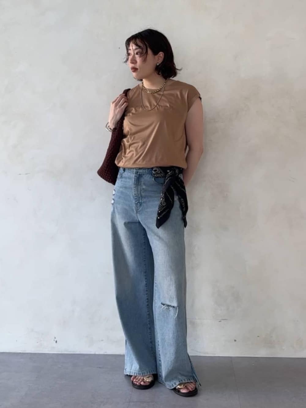 ブルー系のデニムパンツ、ブラウン系のサンダル、イエロー系のTシャツ/カットソーを着用したレディースの夏コーディネートの4枚目の写真