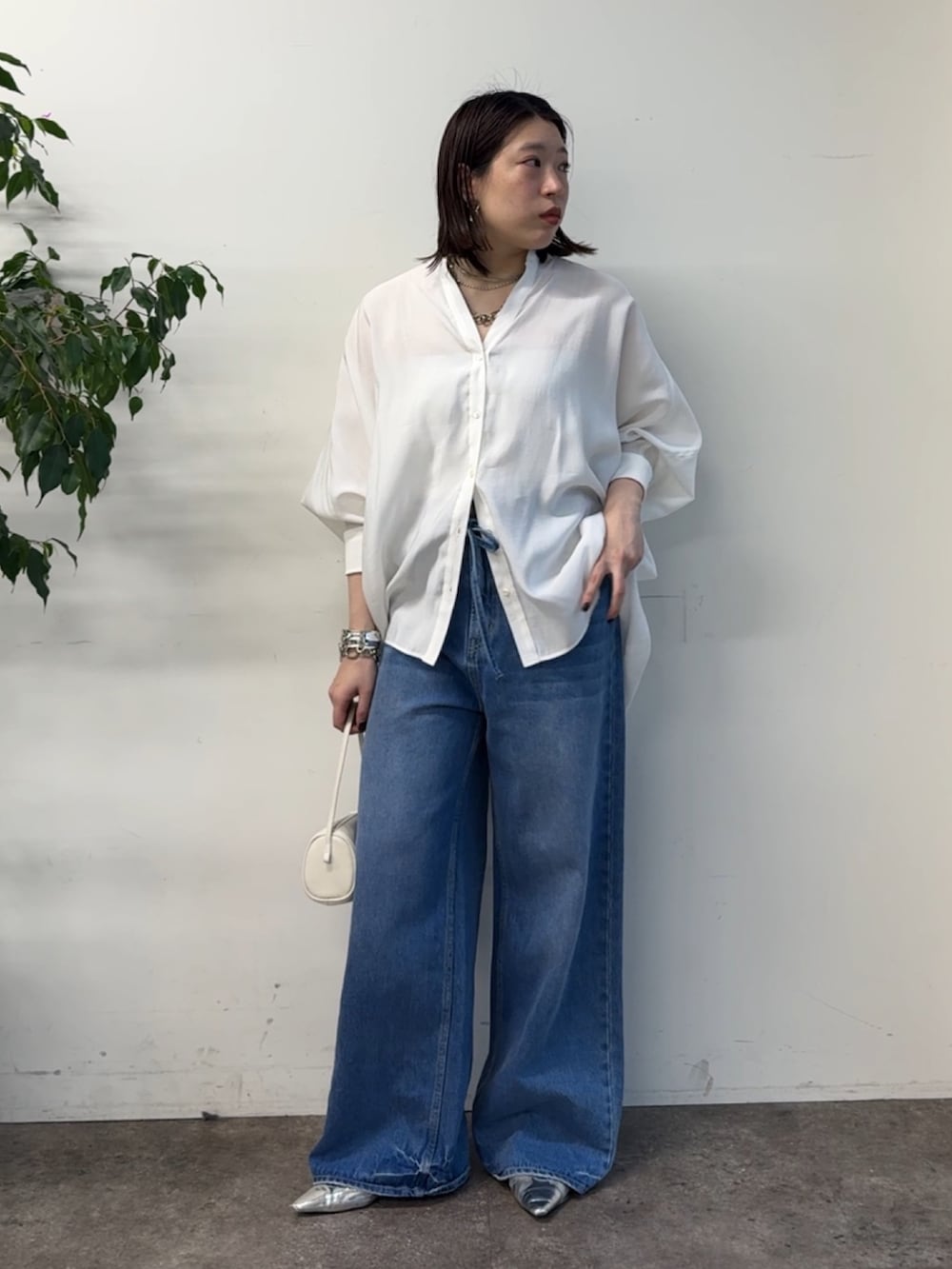 ホワイト系のシャツ/ブラウス、ブルー系のデニムパンツを着用したレディースの冬コーディネートの7枚目の写真