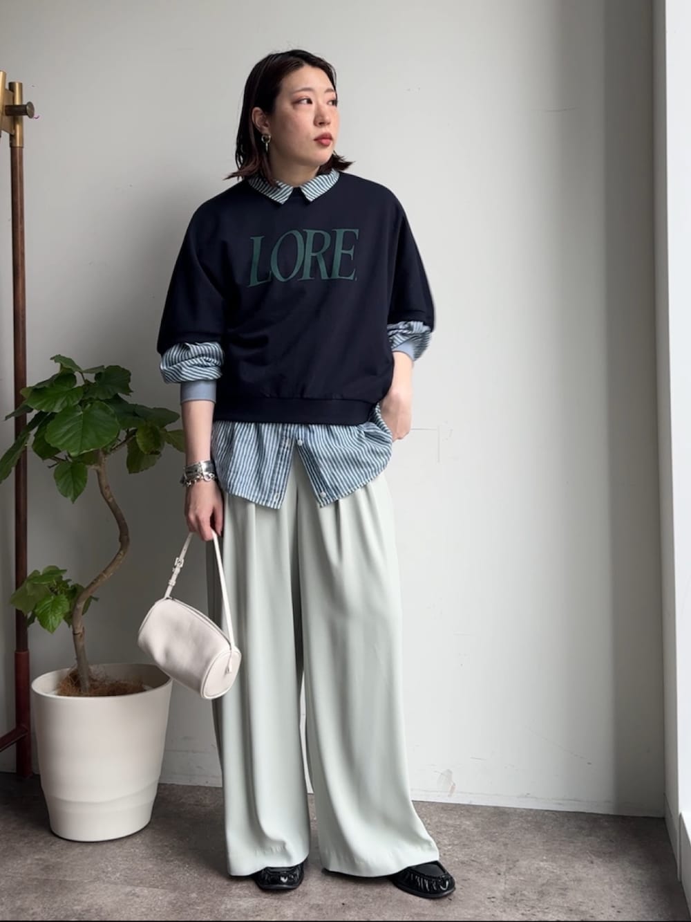 グリーン系のスラックス、ブルー系のシャツ/ブラウス、ブルー系のTシャツ/カットソーを着用したレディースの春コーディネートの7枚目の写真