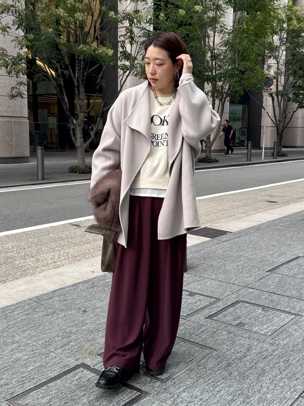 レッド系のスラックス、ベージュ系のその他アウター、ホワイト系のニット/セーターを着用したレディースの秋コーディネートの4枚目の写真