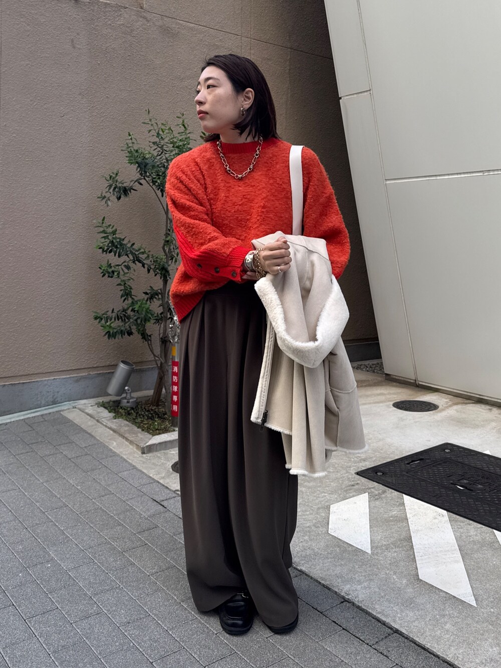 ブラウン系のスラックス、ホワイト系のその他アウター、ホワイト系のショルダーバッグを着用したレディースの秋コーディネートの7枚目の写真