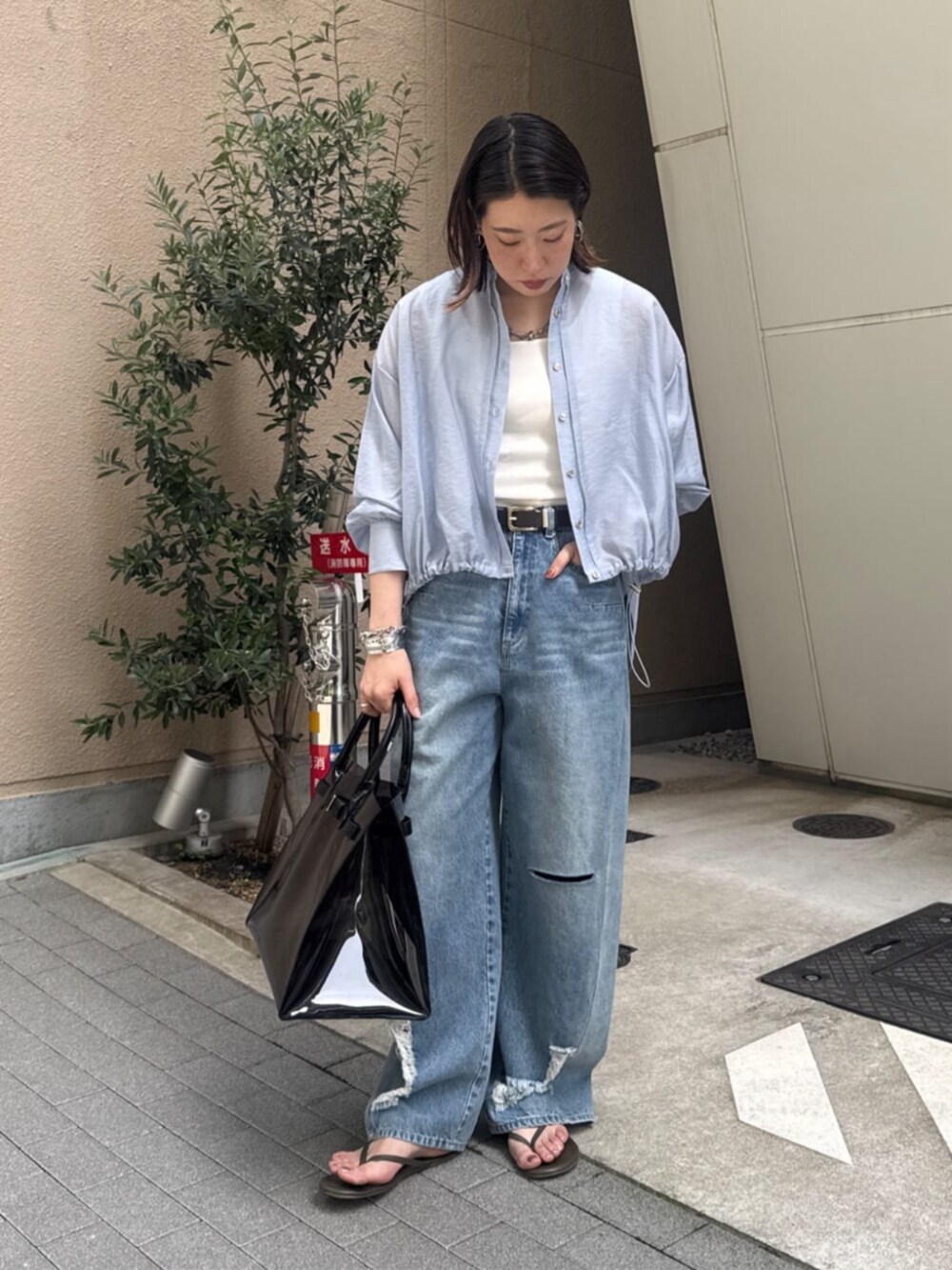 ホワイト系のタンクトップ、ブラック系のショルダーバッグ、ブルー系のデニムパンツを着用したレディースの春コーディネートの9枚目の写真