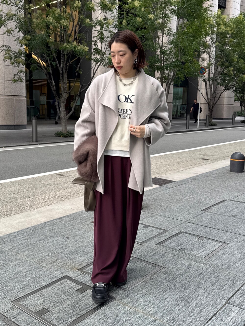 レッド系のスラックス、ベージュ系のその他アウター、ホワイト系のニット/セーターを着用したレディースの秋コーディネートの3枚目の写真