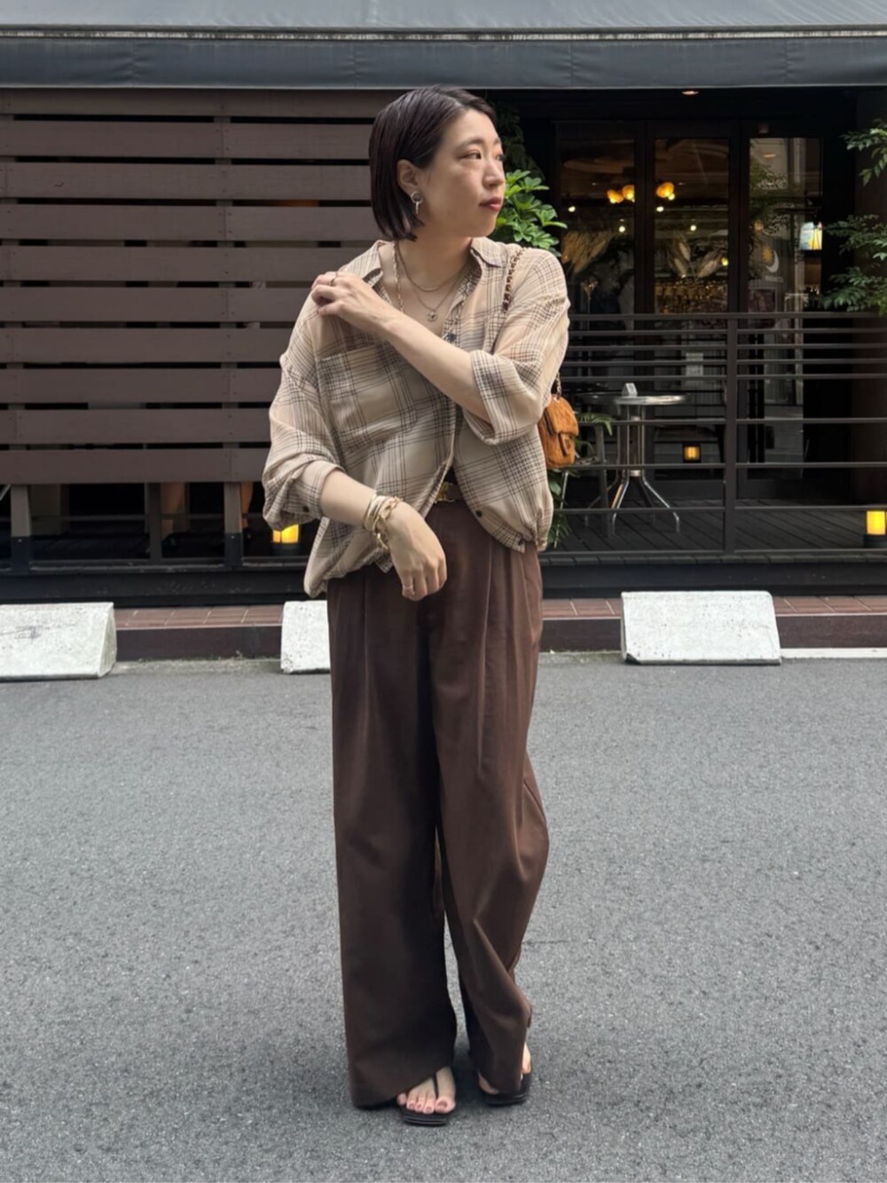 イエロー系のショルダーバッグ、ベージュ系のシャツ/ブラウス、ベージュ系のその他パンツを着用したレディースの夏コーディネートの2枚目の写真