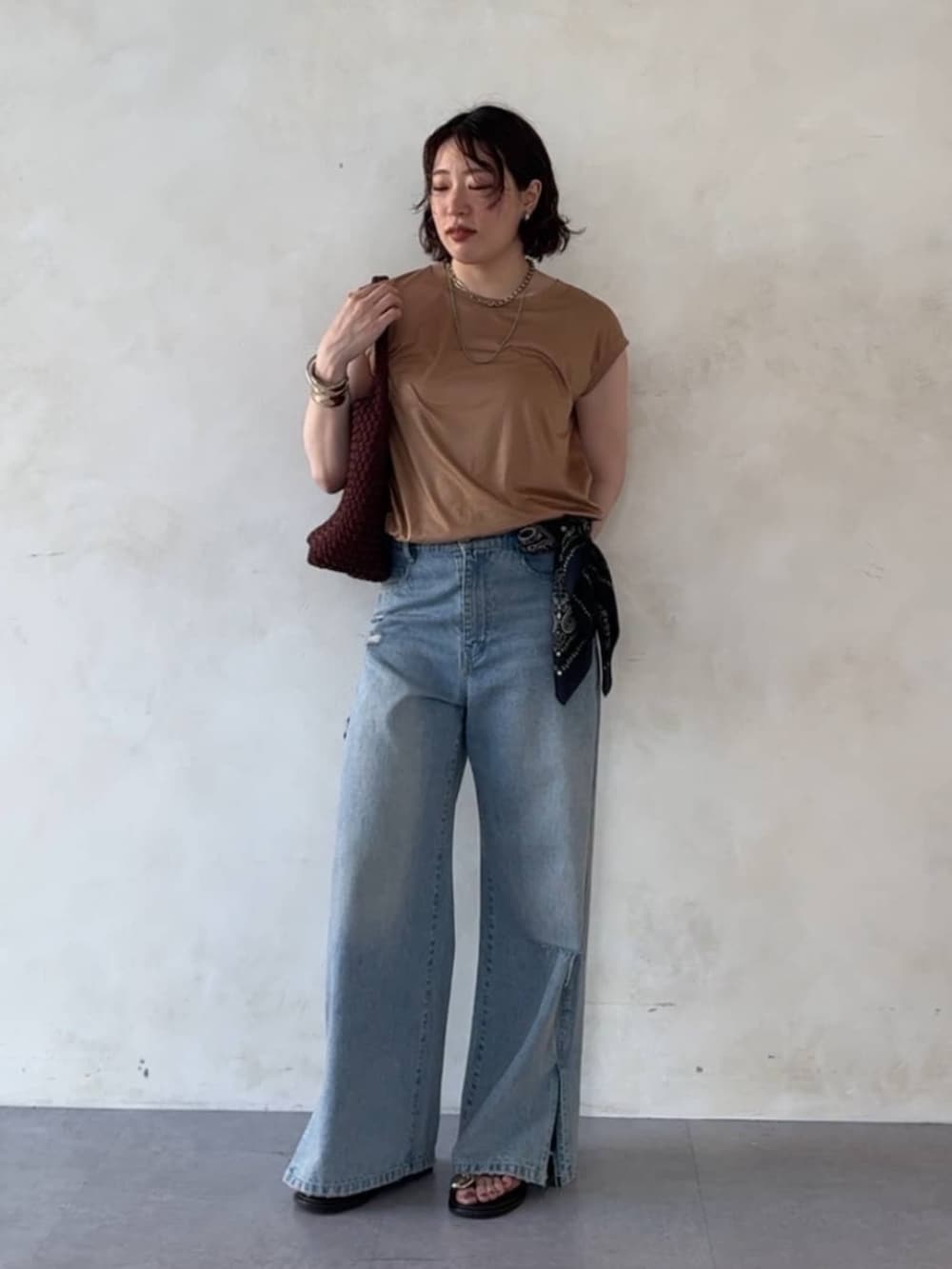 ブルー系のデニムパンツ、ブラウン系のサンダル、イエロー系のTシャツ/カットソーを着用したレディースの夏コーディネートの2枚目の写真