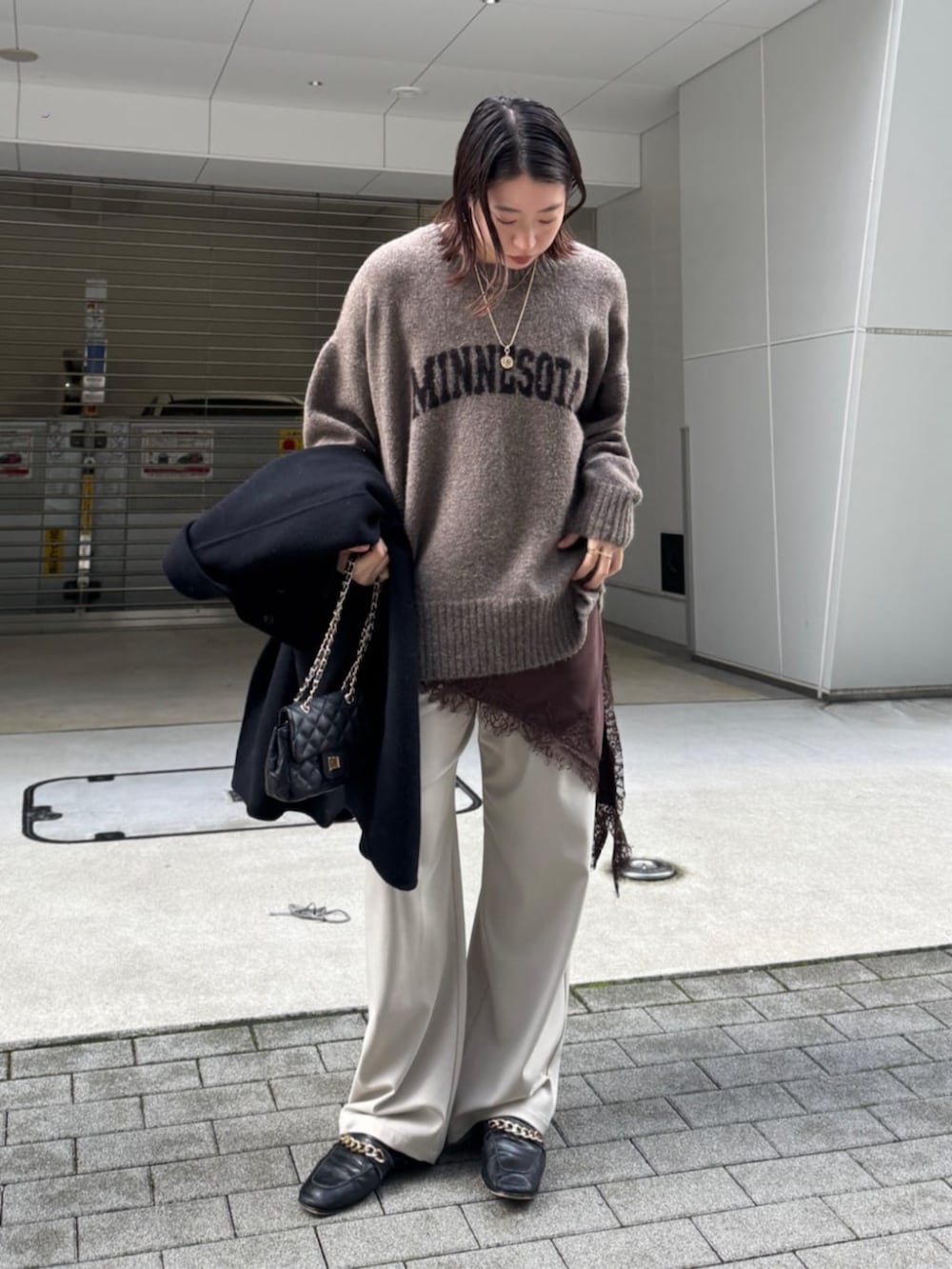 ブラック系のショルダーバッグ、ベージュ系のニット/セーター、ブラウン系のキャミソールを着用したレディースの秋コーディネートの4枚目の写真