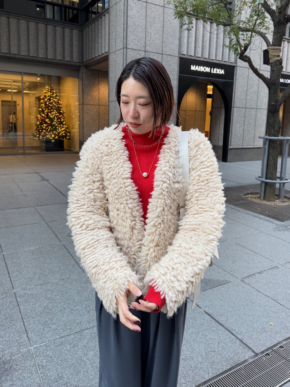 グレー系のスラックス、ホワイト系のショルダーバッグ、ベージュ系のカーディガン/ボレロを着用したレディースの冬コーディネートの7枚目の写真