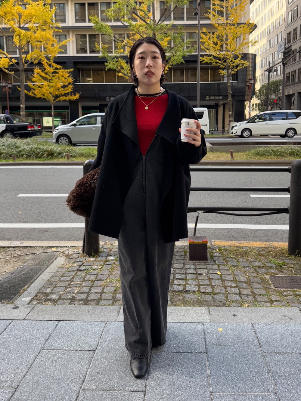 ブラック系のつなぎ/オールインワン、レッド系のニット/セーター、ブラック系のその他アウターを着用したレディースの冬コーディネートの2枚目の写真