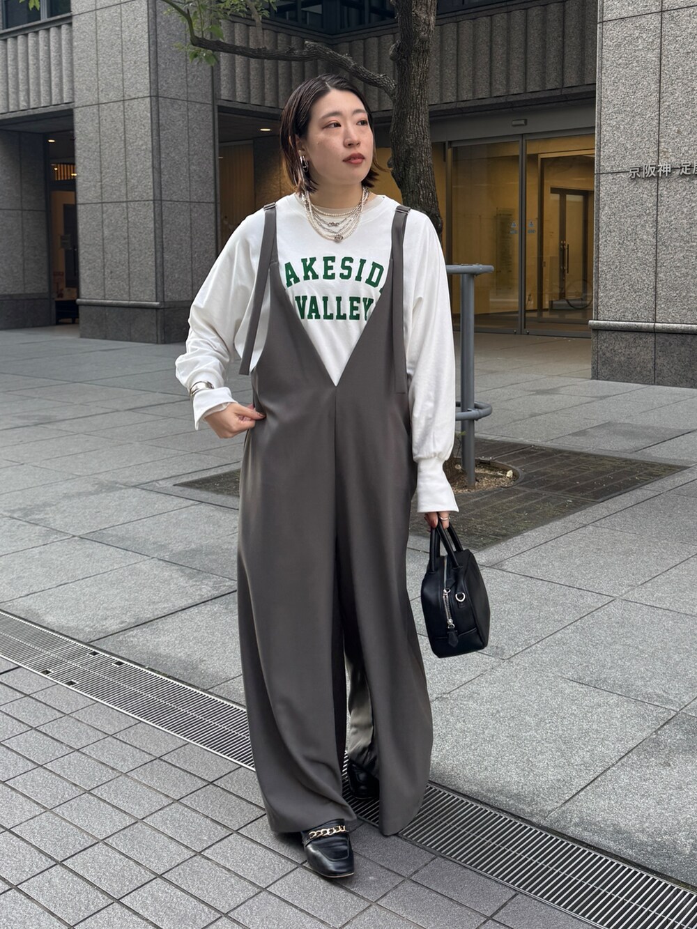 グレー系のつなぎ/オールインワン、ホワイト系のTシャツ/カットソー、シルバー系のネックレスを着用したレディースの冬コーディネートの5枚目の写真